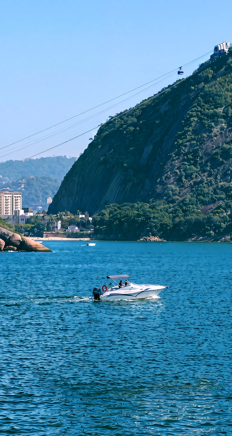 Veleiro e Pão de Açúcar vistos durante passeio de barco na Baía de Guanabara