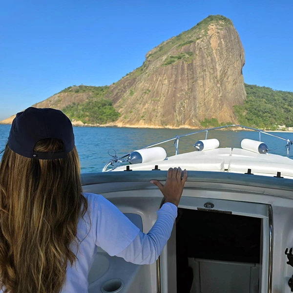 Casal na proa do barco com o Pão de Açúcar à frente